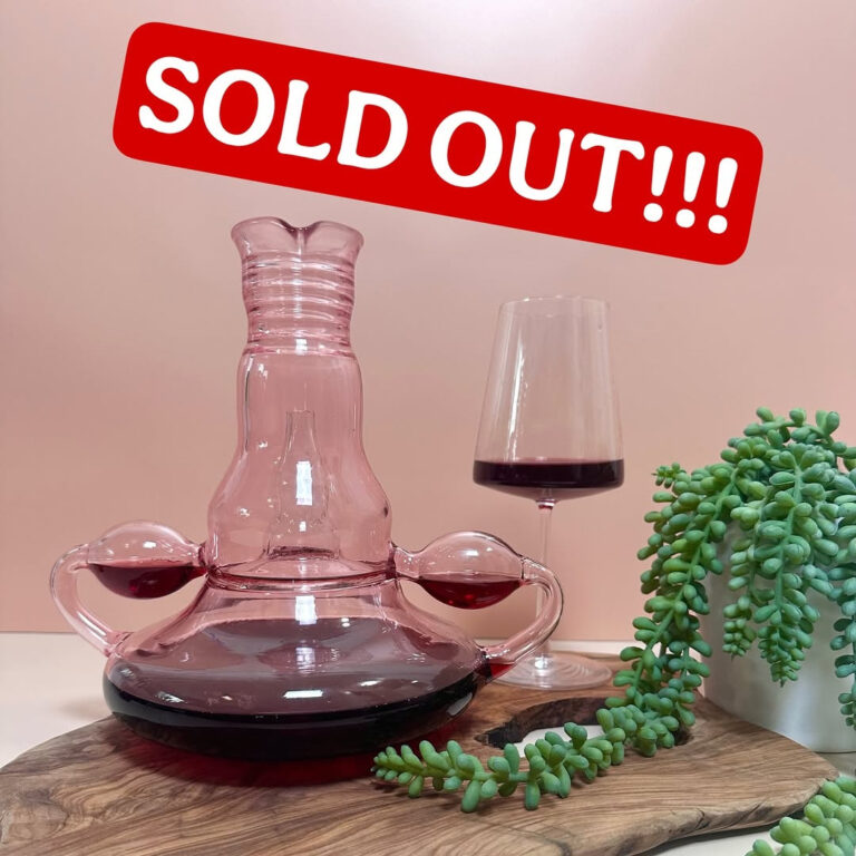 Un decanter con forma de útero, de vidrio rosa, que airea el vino a través de las trompas de Falopio. Hermoso todo. Detrás está la artista queer @nerdster184, de San Diego. Con cada venta dona el 10% a ONGs de salud reproductiva femenina y, lo que empezó como una pieza de vidrio soplado artesanal, se transformó en un boom global. En agosto, en una bodega de Oregón. Un grupo de catadores decidió usar el Shecanter en plena degustación. El vino cayendo por las trompas de Falopio, las risas, los celulares grabando… y el video terminó corriendo como pólvora en TikTok e Instagram. Ese momento fue el disparador que disparó ventas, listas de espera y titulares curiosos en medios.